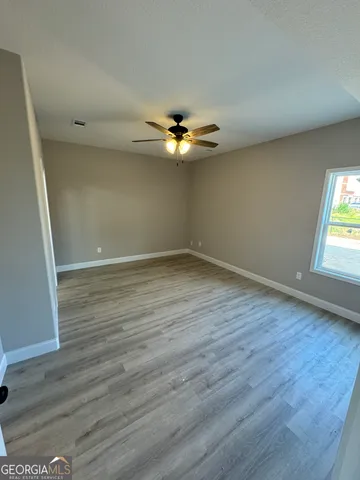wooden floor in an empty room with a window