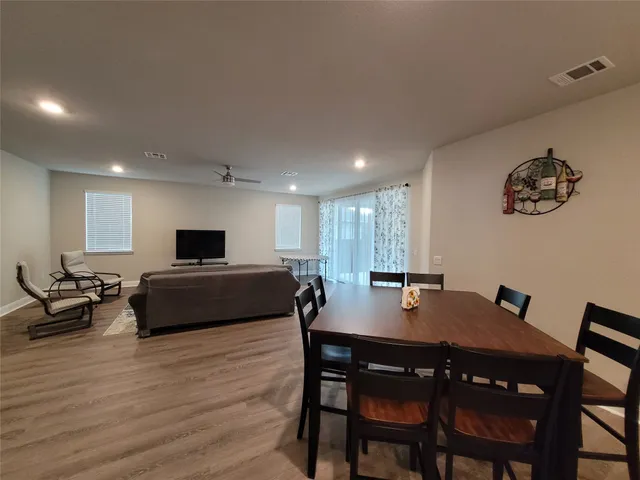 a living room with a table chairs and a wooden floor