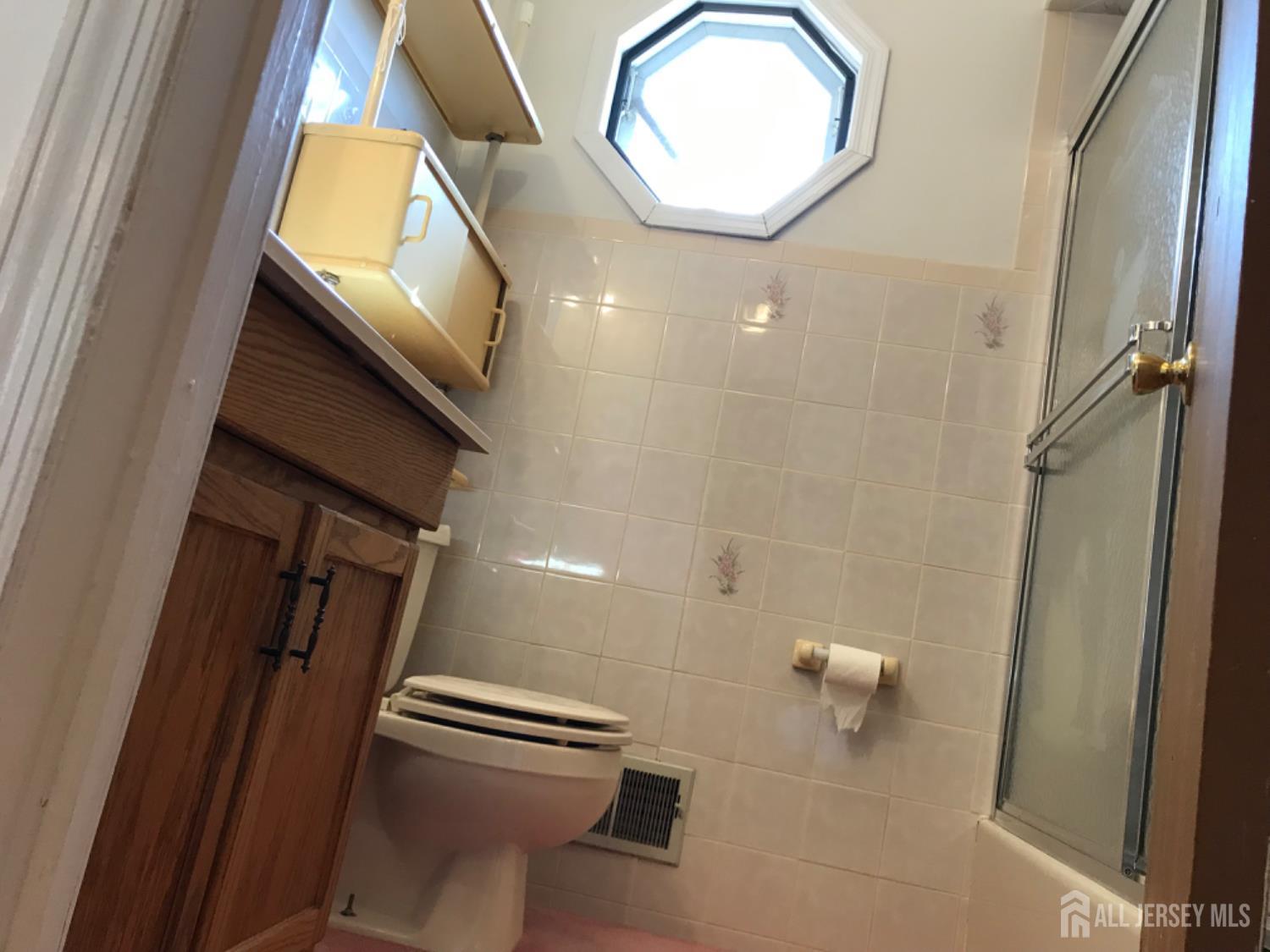 689 Mary Street Perth Amboy, NJ 08861 - Photo 14 of 24 a bathroom with a sink a toilet and a mirror