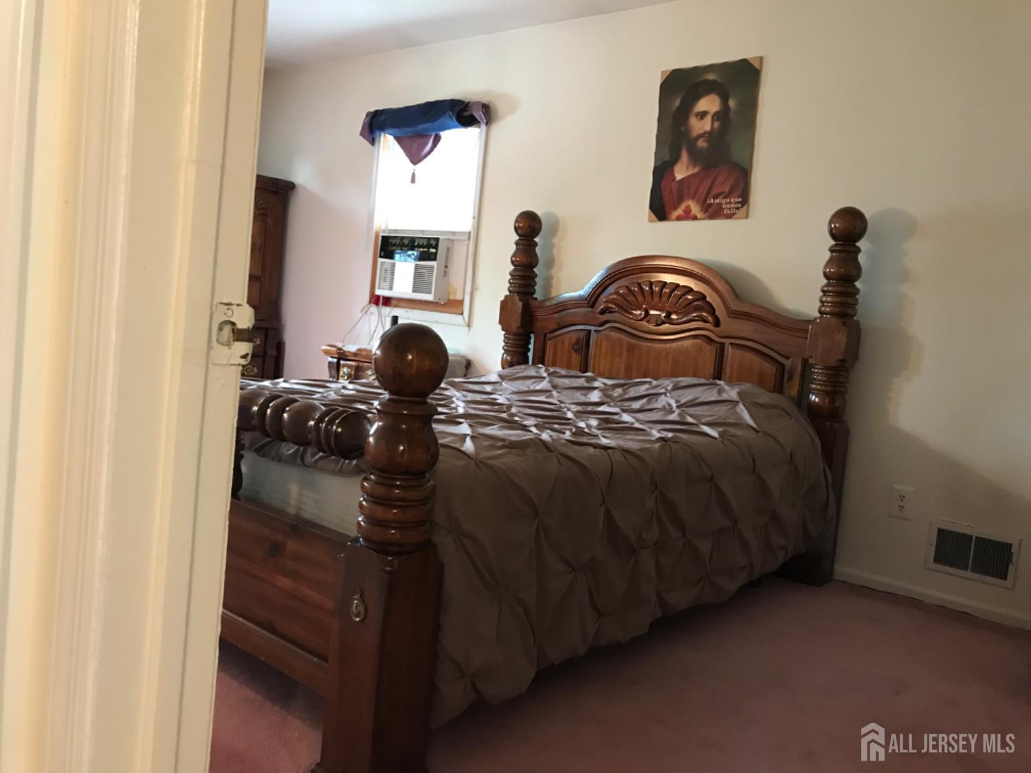 689 Mary Street Perth Amboy, NJ 08861 - Photo 18 of 24 a bedroom with a bed and a mirror