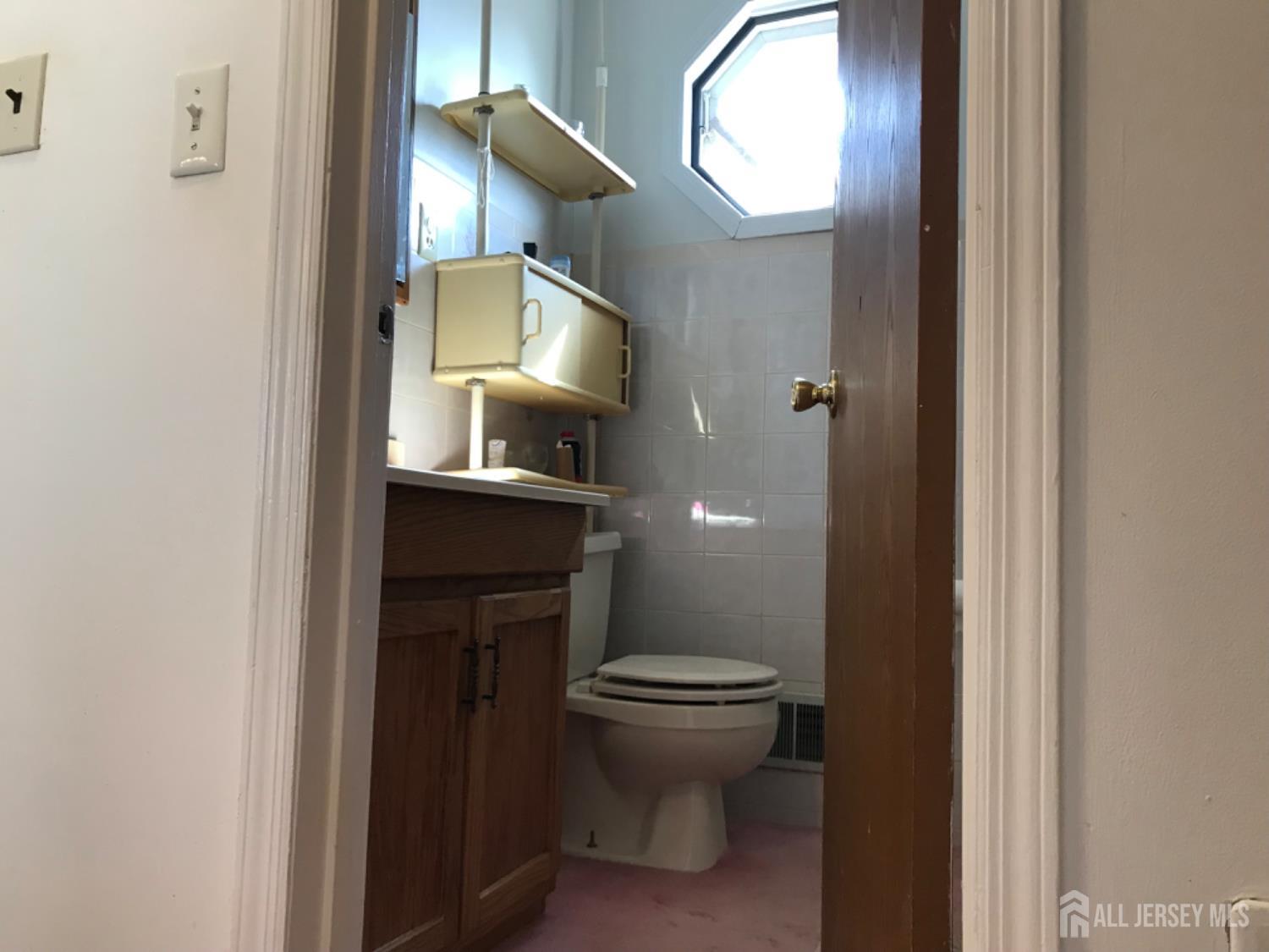 689 Mary Street Perth Amboy, NJ 08861 - Photo 19 of 24 a bathroom with a toilet and a mirror