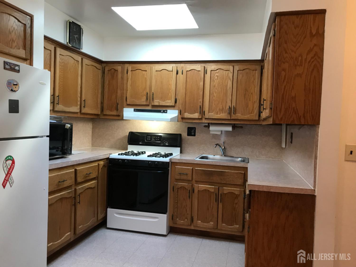 689 Mary Street Perth Amboy, NJ 08861 - Photo 4 of 24 a kitchen with stainless steel appliances granite countertop a stove a sink and a refrigerator