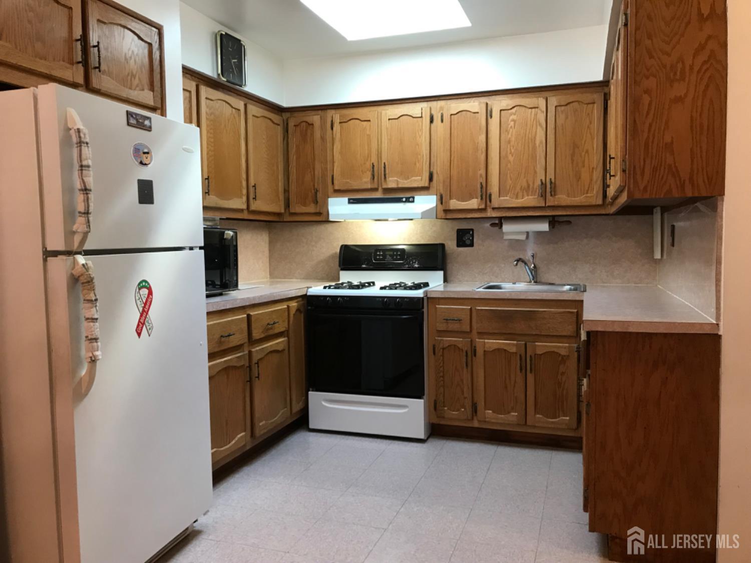 689 Mary Street Perth Amboy, NJ 08861 - Photo 5 of 24 a kitchen with stainless steel appliances granite countertop a refrigerator a stove a sink and cabinets