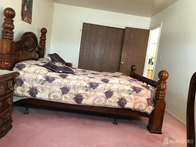 a bed sitting in a bedroom next to a window and dresser