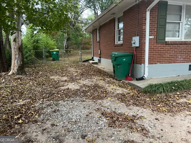 a view of a backyard with plants and large tree