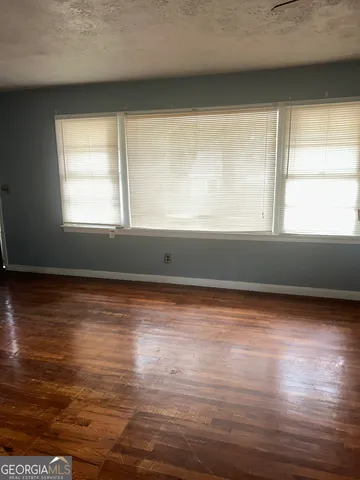 a view of a room with wooden floor and a window