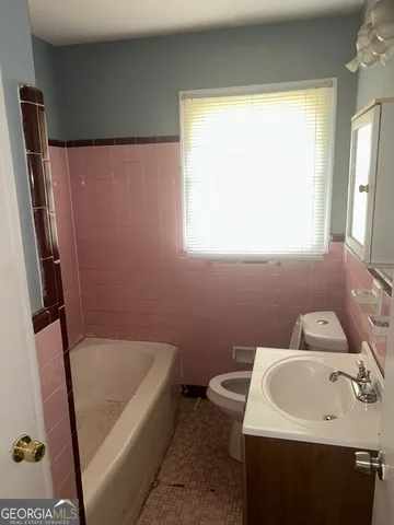 a bathroom with a sink a window and a bathtub