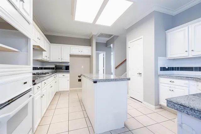 a kitchen with granite countertop white cabinets and white appliances