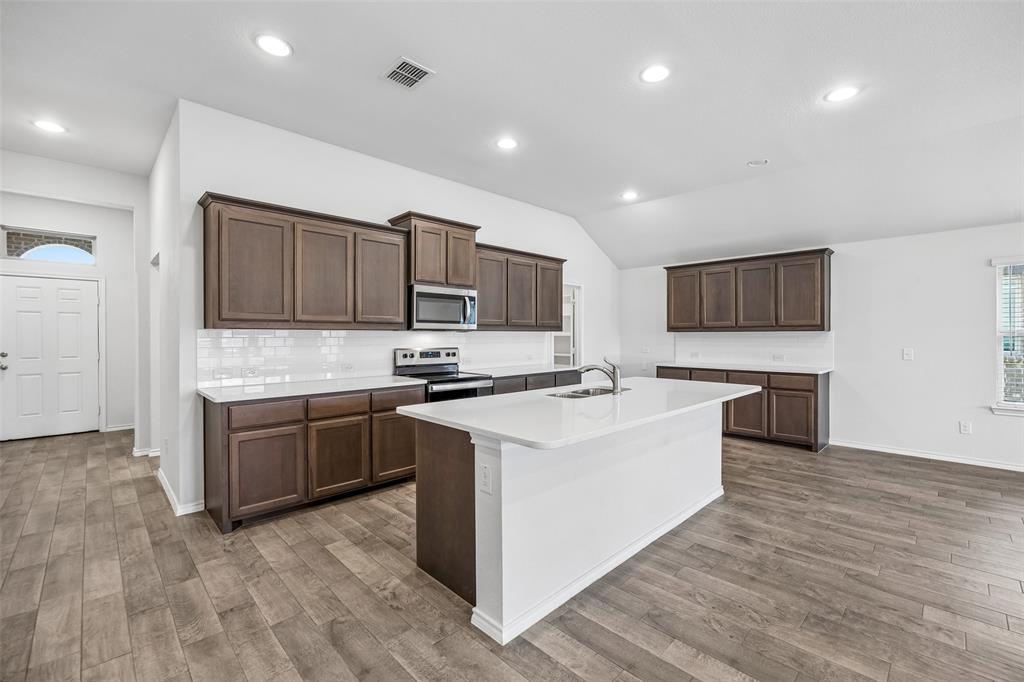 3807 Dogwood Road Melissa, TX 75454 - Photo 4 of 38 a large kitchen with stainless steel appliances granite countertop a stove a sink and a microwave