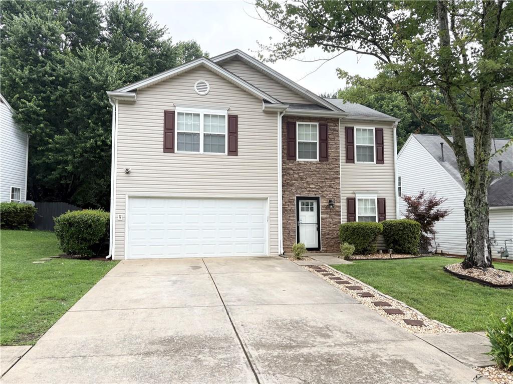 a front view of a house with a yard and garage