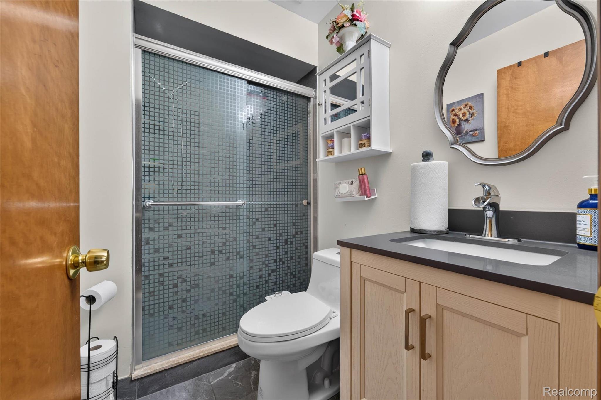 46362 Springhill Drive Utica, MI 48317 - Photo 17 of 59 Bathroom featuring a light wood-finish vanity with a dark countertop, an undermount sink, and brushed nickel hardware