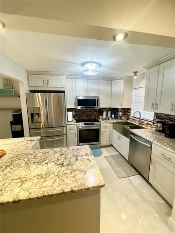 a kitchen with granite countertop a stove and cabinets