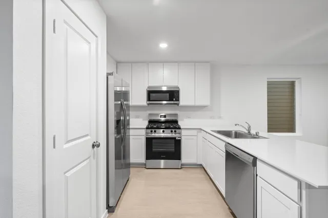 a kitchen with a sink stove and refrigerator