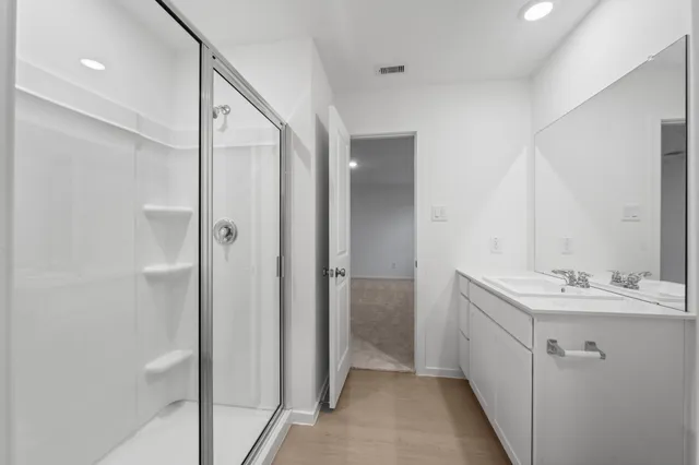 a bathroom with a double vanity sink mirror and shower