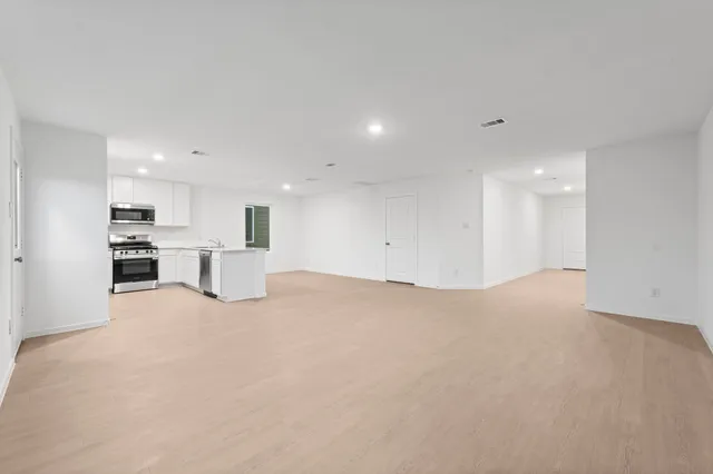 a view of kitchen with refrigerator and white cabinets