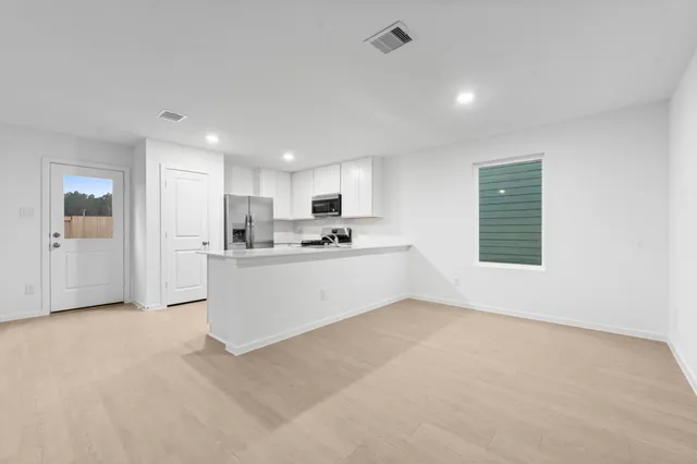 a view of kitchen with kitchen island and stainless steel appliances