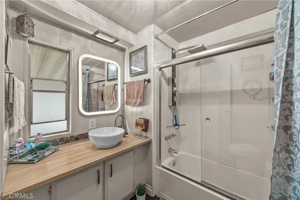 a bathroom with a granite countertop sink a mirror and a shower