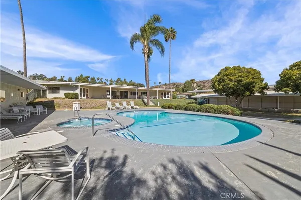 a view of a swimming pool with a patio and a yard