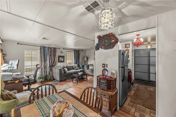 a living room with furniture a chandelier and a flat screen tv