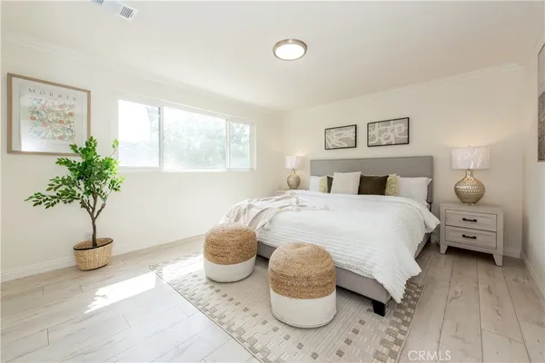 a bedroom with a bed and a potted plant