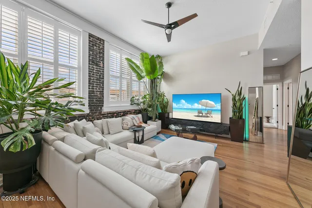 a living room with furniture a potted plant and a flat screen tv