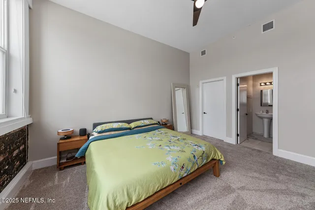 a spacious bedroom with a bed and a window