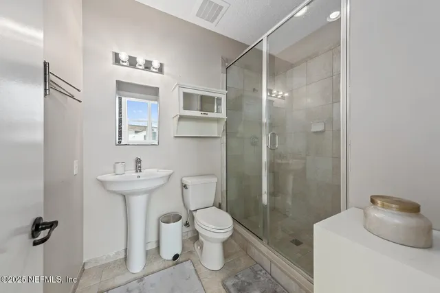 a spacious bedroom with a bed and a chandelier