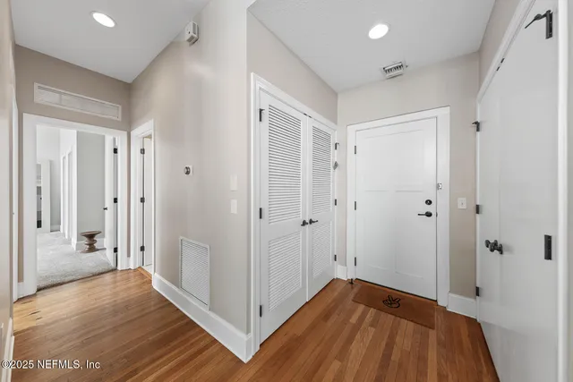 a view of a hallway with wooden floor