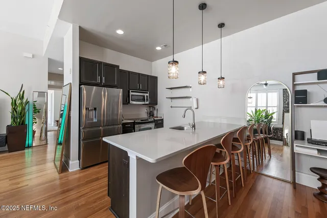 a kitchen with granite countertop a counter space dining table and stainless steel appliances