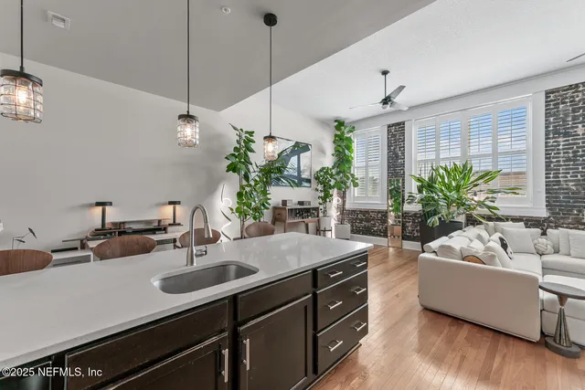 a kitchen with stainless steel appliances granite countertop a refrigerator a sink a stove a dining table and chairs