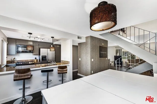 a kitchen with stainless steel appliances a dining table chairs and white cabinets