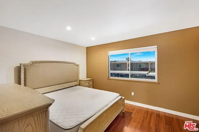 a bedroom with a bed and painting on the wall