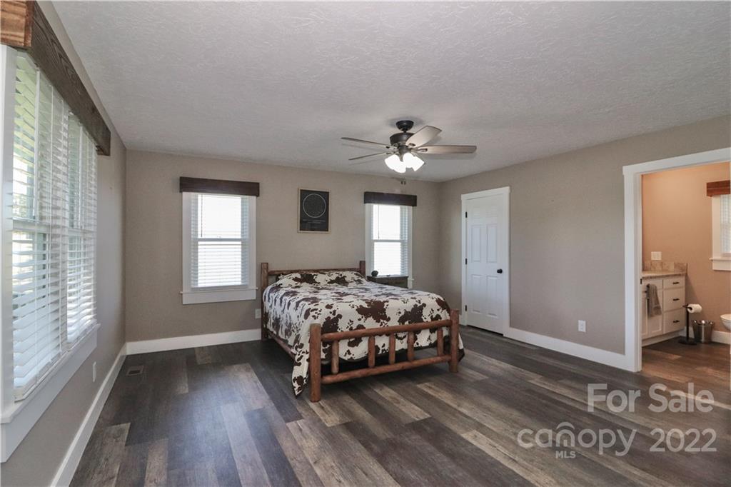 147 Stack Road Olin, NC 28660 - Photo 17 of 47 a spacious bedroom with a bed and a chandelier