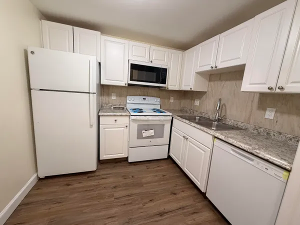 a kitchen with white cabinets and white appliances