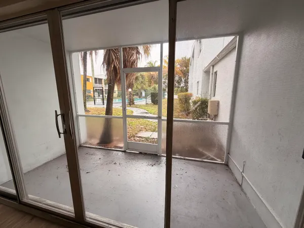 a view of empty room with wooden floor and floor to ceiling window