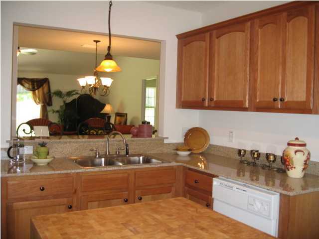 5214 Moore Loop Crestview, FL 32536 - Photo 7 of 13 a kitchen with kitchen island granite countertop a sink a counter space and cabinets