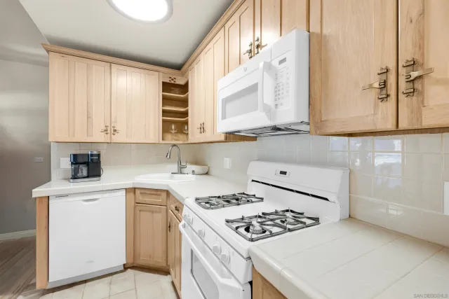 a kitchen with stainless steel appliances cabinets and a window
