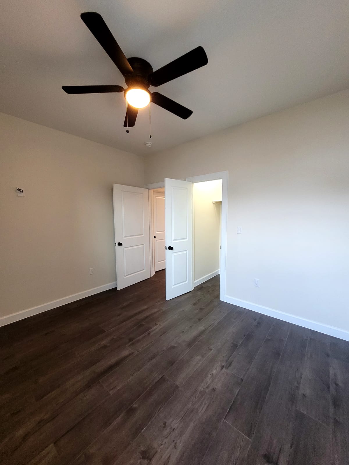 750 South Main Street Lockhart, TX 78644 - Photo 13 of 31 Unfurnished bedroom featuring dark wood-style flooring and ceiling fan