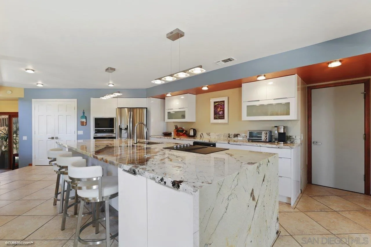 1778 Kings Road Vista, CA 92084 - Photo 20 of 49 a large kitchen with kitchen island a stove a sink a dining table and chairs