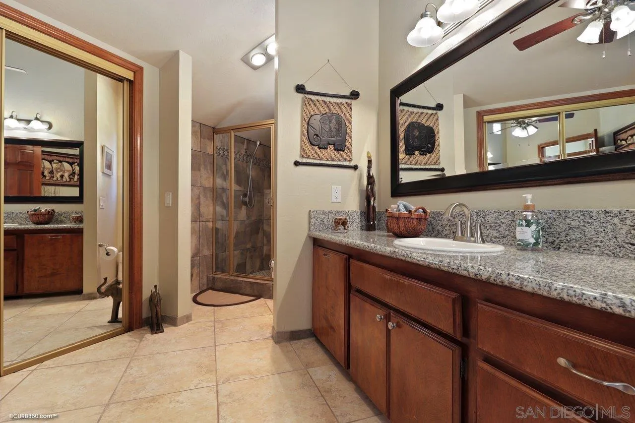 1778 Kings Road Vista, CA 92084 - Photo 40 of 49 a spacious bathroom with a granite countertop sink and a mirror