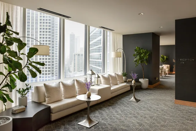 a living room with furniture and floor to ceiling windows and wooden floor