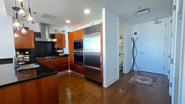 a kitchen with stainless steel appliances granite countertop a refrigerator and a stove