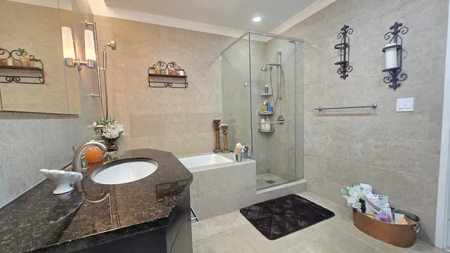 a bathroom with a granite countertop sink a mirror and shower