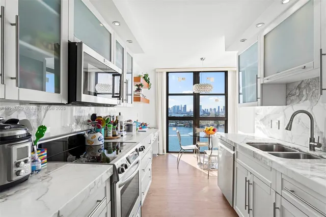 a kitchen that has a lot of cabinets a sink and wooden floor