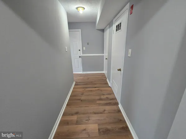 a view of a hallway with wooden floor and staircase