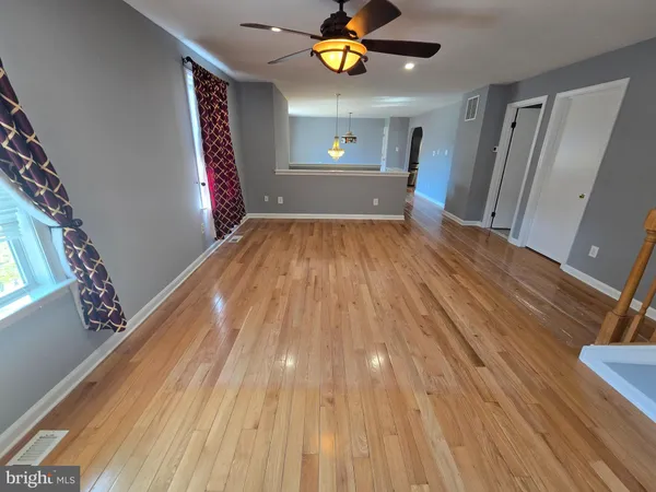a view of empty room with wooden floor