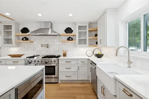 a kitchen with stainless steel appliances granite countertop a stove and a sink