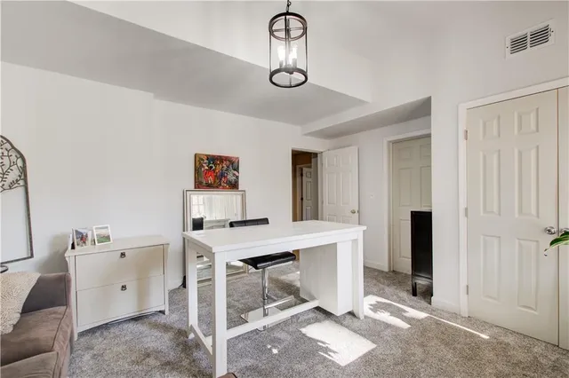 a view of a workspace with furniture and a window