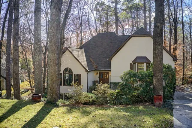 a view of a house with a yard and potted plants