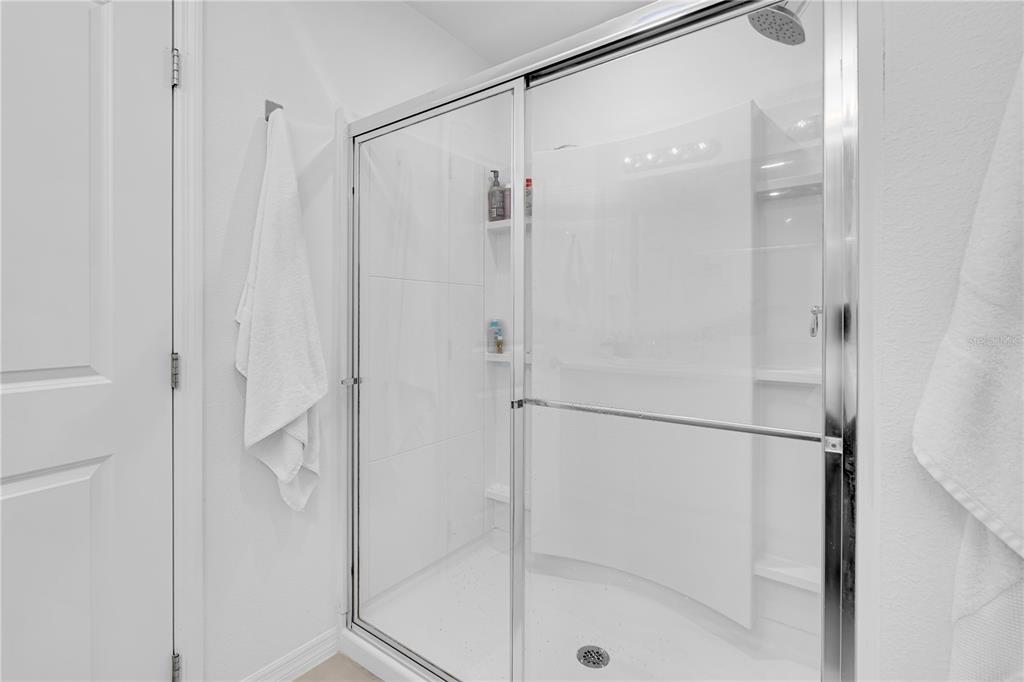 4226 Southern Vista Loop St. Cloud, FL 34772 - Photo 17 of 39 a bathroom with a glass shower door